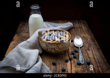 Milchflasche und Schüssel Müsli mit Heidelbeeren und Quinoa Stockfoto