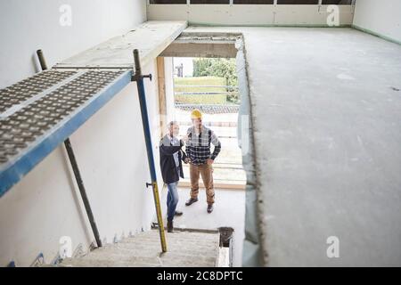 Architekt und Arbeiter im Gespräch auf einer Baustelle Stockfoto