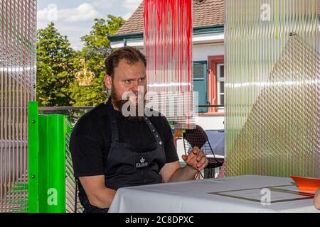 Außengastronomie mit künstlerisch gestalteten Trennwänden und Kellner mit Schutzmasken im Hotel Krone in weil am Rhein, Deutschland Stockfoto