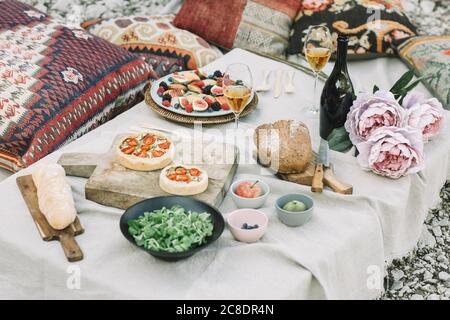 Blick auf verschiedene Speisen mit Wein und Blumen Auf dem Tisch Stockfoto
