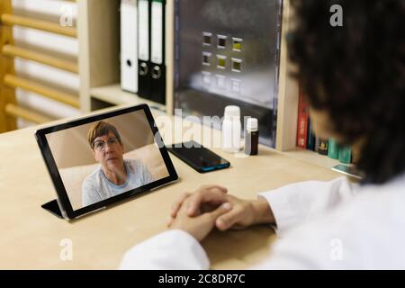 Ältere Frau auf dem digitalen Tablet-Bildschirm während eines Videoanrufs mit Arzt Stockfoto