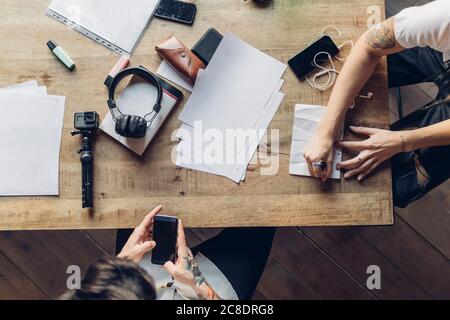 Zwei kreative Geschäftsleute, die am Holztisch arbeiten Stockfoto