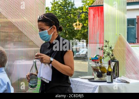 Außengastronomie mit künstlerisch gestalteten Trennwänden und Kellner mit Schutzmasken im Hotel Krone in weil am Rhein, Deutschland Stockfoto