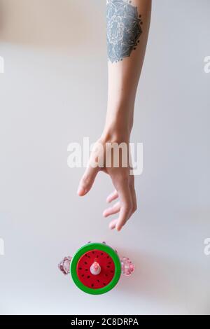 Nahaufnahme einer Frau, die in Richtung des Behälters auf dem Tisch greift Zu Hause Stockfoto