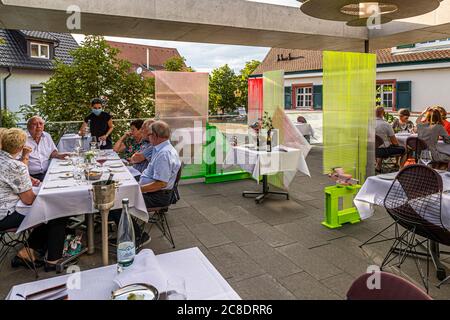 Außengastronomie mit künstlerisch gestalteten Trennwänden und Kellner mit Schutzmasken im Hotel Krone in weil am Rhein, Deutschland Stockfoto