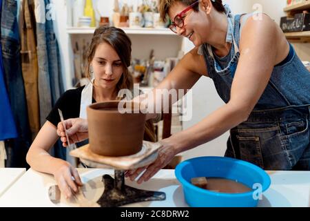 Reife Frau, die im Studio einer Kollegin Töpferei beibringt Stockfoto