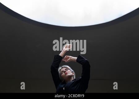 Elegante professionelle Frau in elegantem Anzug, der gegen das beleuchtete Licht steht Im Büro Stockfoto