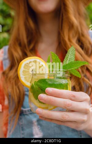 Nahaufnahme einer jungen Frau mit frischem Mojito-Cocktail auf dem Rücken Hof Stockfoto