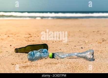 Glas- und Plastikflaschen liegen auf Strandsand Stockfoto