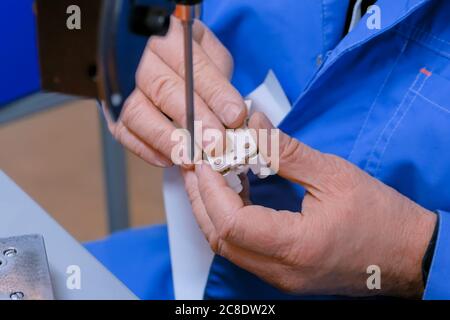 Blind man Assembler, Elektriker Hände Montage Steckdose am Stoff. Reparatur, Produktion, handgemachte Herstellungsprozess, Strom und Stockfoto