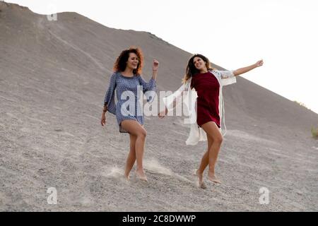 Fröhliche Freundinnen tanzen auf dem Hügel auf dem Land Stockfoto