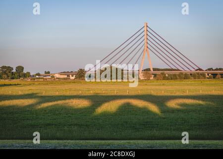Deutschland, Nordrhein-Westfalen, Wesel, Schatten der Wesel Eisenbahnbrücke mit Niederrheinbrücke Wesel im Hintergrund Stockfoto