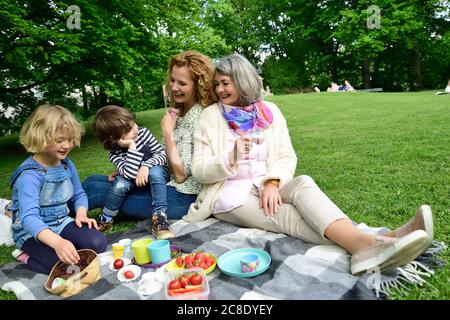 Glückliche drei Generationen Familie genießen Picknick im öffentlichen Park Stockfoto