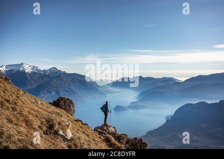 Wanderer, der auf dem Berg steht und auf den Comer See blickt, Italien Stockfoto