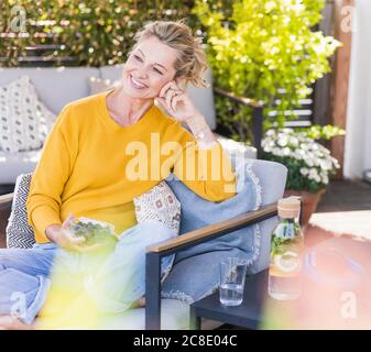 Portrait der glücklichen reifen Frau entspannen auf der Terrasse Stockfoto