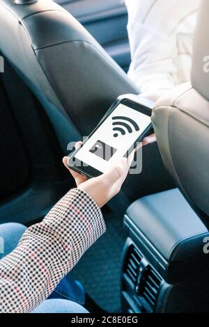 Kurze Hand der Frau, die mobile Zahlung im Taxi Stockfoto