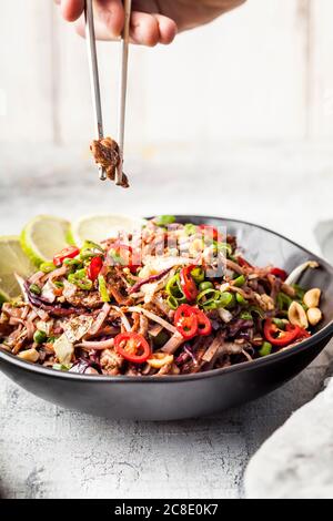 Gebratene Reisnudeln mit Gemüse, Pad Thai-Stil mit Jungen Hand halten Essstäbchen Stockfoto