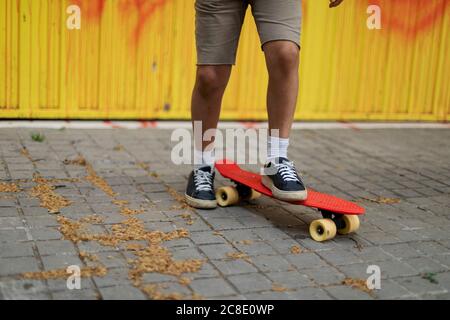 Beine des Jungen Skateboarding auf Fußpfad Stockfoto
