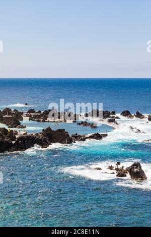 Portugal, Porto Moniz, kleine felsige Bucht am Ufer der Insel Madeira mit klarer Horizontlinie über dem Atlentischen Ozean im Hintergrund Stockfoto