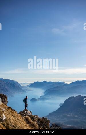 Wanderer, der auf dem Berg steht und auf den Comer See blickt, Italien Stockfoto