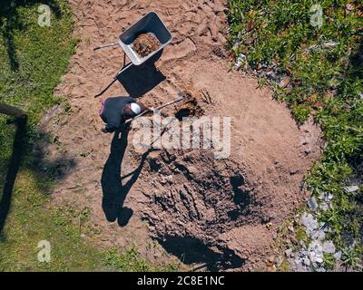 Luftaufnahme des Menschen, der Sand auf Schubkarre lastet Stockfoto