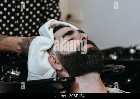 Friseur trocknet die Haare des Kunden mit Handtuch im Salon Stockfoto