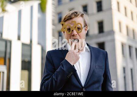 Geschäftsmann trägt 2020 Comedy-Brille in der Stadt Finger setzen Im Mund Stockfoto