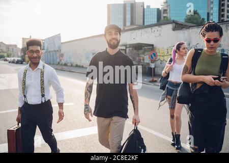 Eine Gruppe von Freunden, die auf einer Straße in der Stadt spazieren gehen Stockfoto