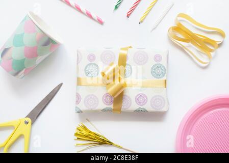 Studio-Aufnahme von eingewickelten Geburtstagsgeschenk und verschiedenen Geburtstagrequisiten Stockfoto