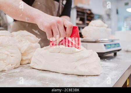 Bäckerin bereitet Brotlaib an der Küchentheke in der Bäckerei vor Stockfoto