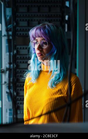 Nahaufnahme einer nachdenklichen jungen Frau mit gefärbten Haaren und Piercings Im alten Büro Stockfoto
