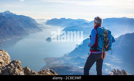 Wanderer, der auf dem Berg steht und auf den Comer See blickt, Italien Stockfoto