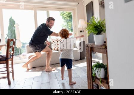 Glücklicher Vater und Sohn spielen im Wohnzimmer zu Hause Stockfoto