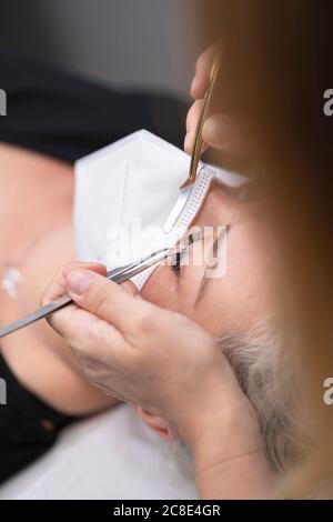 Nahaufnahme der weiblichen Kunden bekommen Wimpern Behandlung von Kosmetikerin an Spa Stockfoto