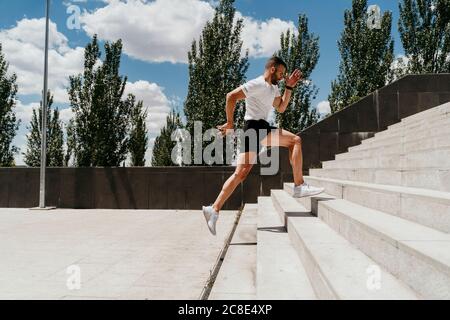 Männlicher Athlet, der die Treppe hinauf läuft Stockfoto