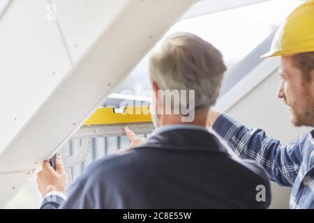 Architekt und Arbeiter Messfenster auf einer Baustelle Stockfoto