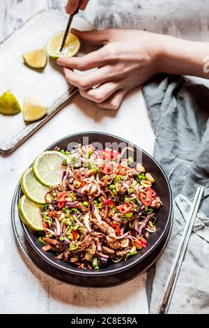 Gebratene Reisnudeln mit Gemüse, Pad Thai-Stil mit Jungen Hand schneiden Zitrone Stockfoto