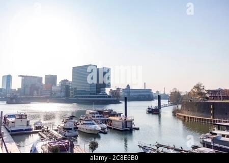 Deutschland, Nordrhein-Westfalen, Düsseldorf, Boote im Medienhafen mit Stadttor im Hintergrund Stockfoto