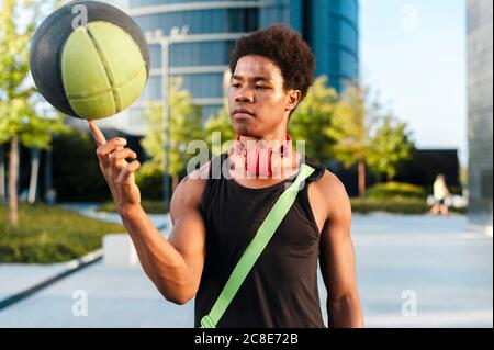 Porträt eines jungen Mannes, der Basketball an der Fingerspitze dreht Stockfoto