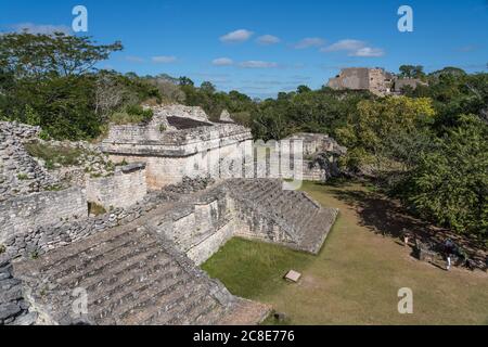 Die teilweise restaurierten Ruinen der Zwillingstempel auf der Oberseite der Struktur 17 mit der großen Ruine der Akropolis in den Ruinen der prähispanischen Maya CI Stockfoto