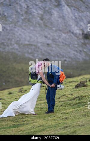 Küssendes Brautpaar mit Kletterrucksäcken, Urkiola Berg, Spanien Stockfoto