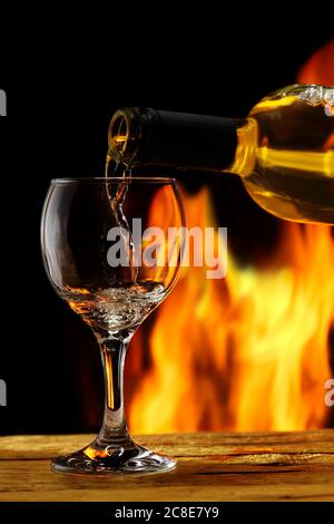 Vor dem Kamin wird Wein gegossen Stockfoto