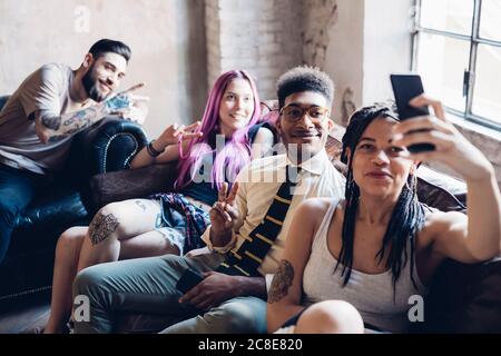 Gruppe von Freunden sitzen auf dem Sofa in einem Lofttaking ein Selfie Stockfoto