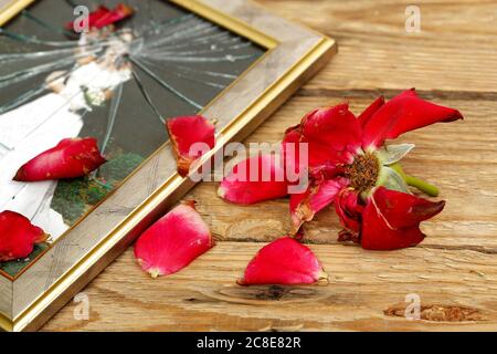 Verwelkte Rose und zerbrochene Hochzeitsbild Stockfoto