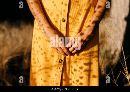 Nahaufnahme einer jungen Frau in gelbem Kleid im Wald Stockfoto