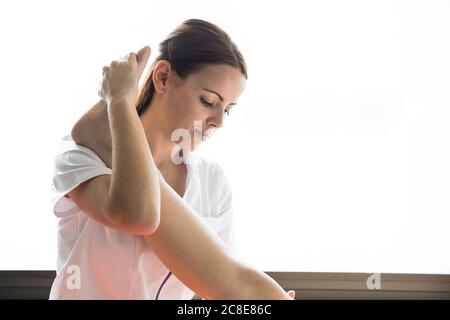 Weibliche Physiotherapeutin Stretching Bein der Patientin Stockfoto