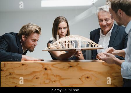 Erfolgreiche Geschäftsleute, die Architekturmodelle im Büro betrachten Stockfoto