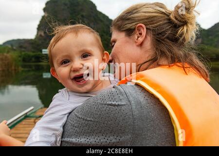 Vietnam, Mutter mit Baby im Boot in Trang an Scenic Landscape Complex Stockfoto