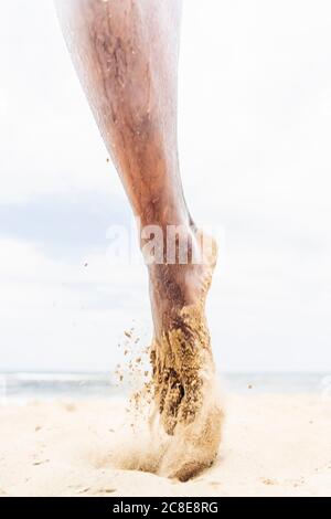 Sandiger Fuß des Laufmanns am Strand Stockfoto