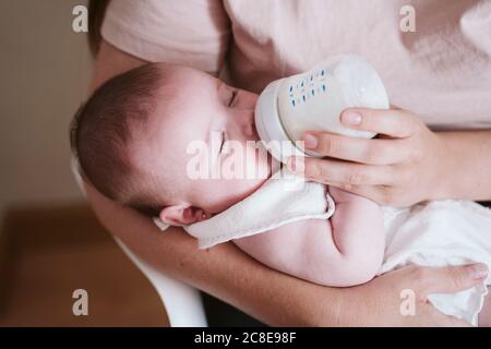 Mutter Flasche Fütterung Baby Mädchen zu Hause Stockfoto
